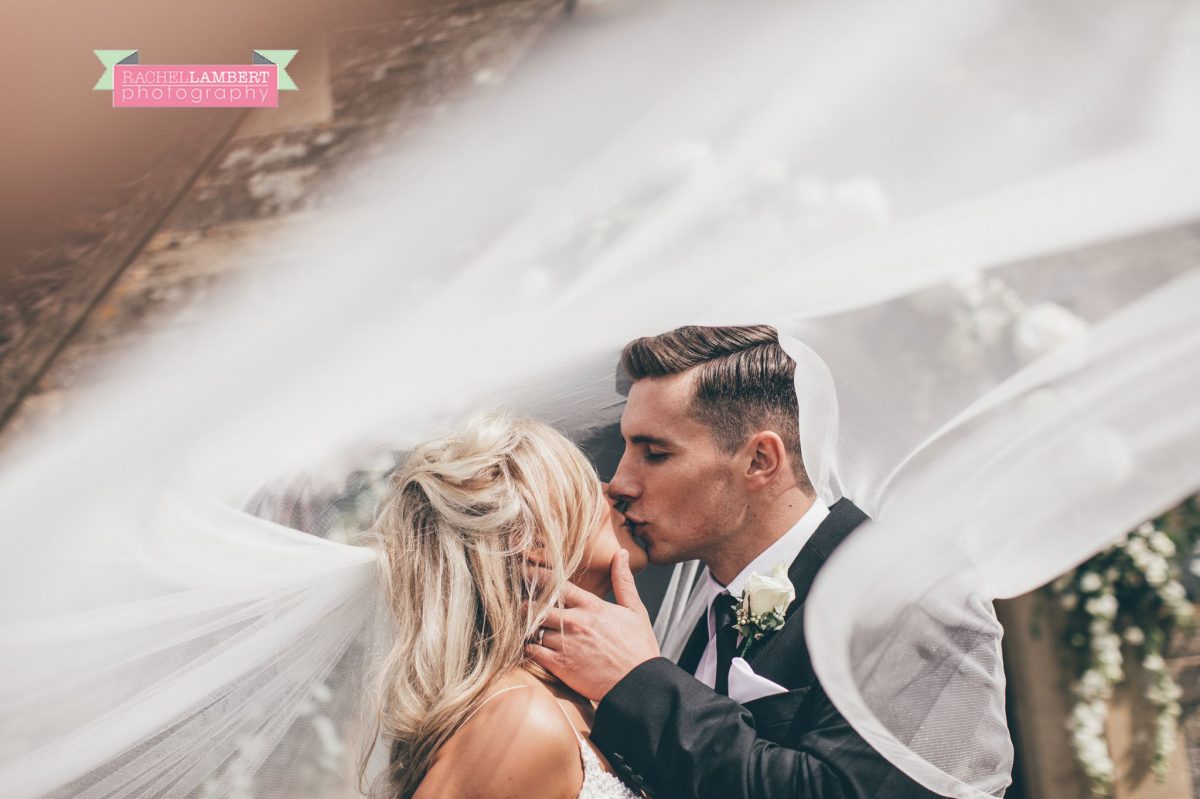 bride and groom portrait outside church wedding long veil