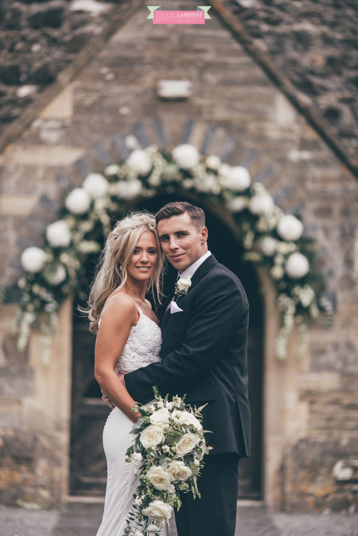 bride and groom outside church wedding flower arch bridal flowers