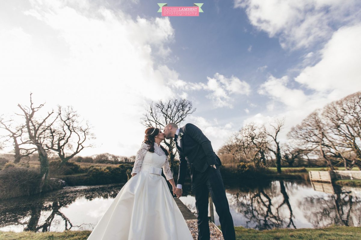  bride and groom kissing with lake in background