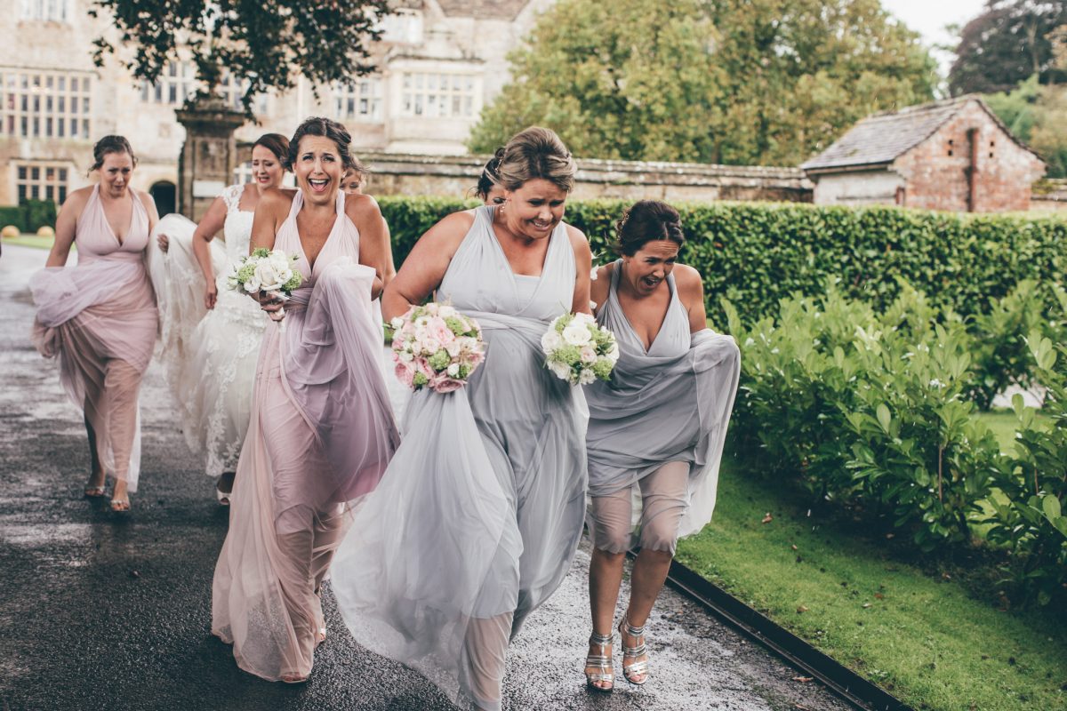 bridesmaids running to the church in the rain rachel lambert photography north cadbury court